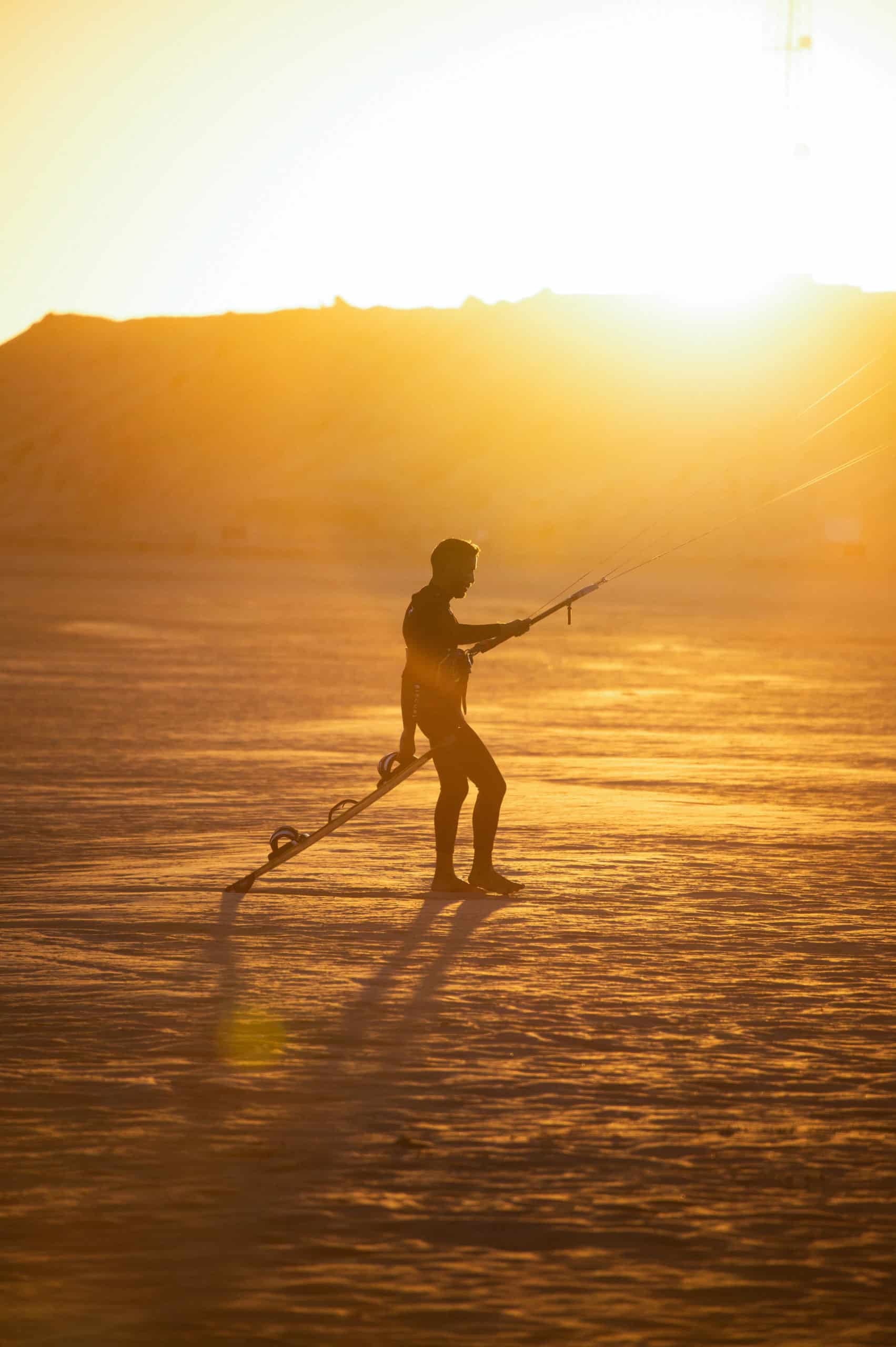 Caravan by Dakhla Kite Experience 6 Kitesurfeur qui lève son aile en plein coucher de soleil en Égypte