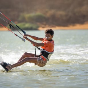 Junges Kind beim Kitesurfen in Mayapo, Kolumbien